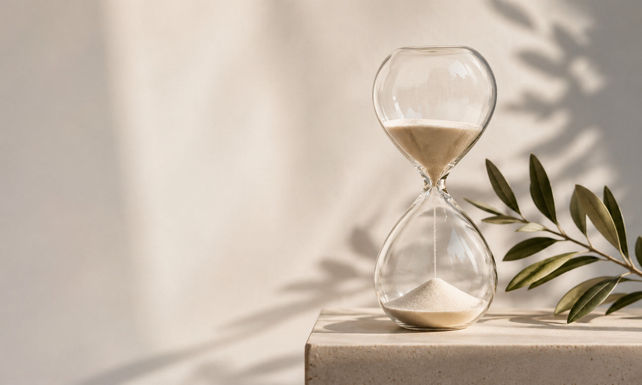 An hourglass beside an olive branch